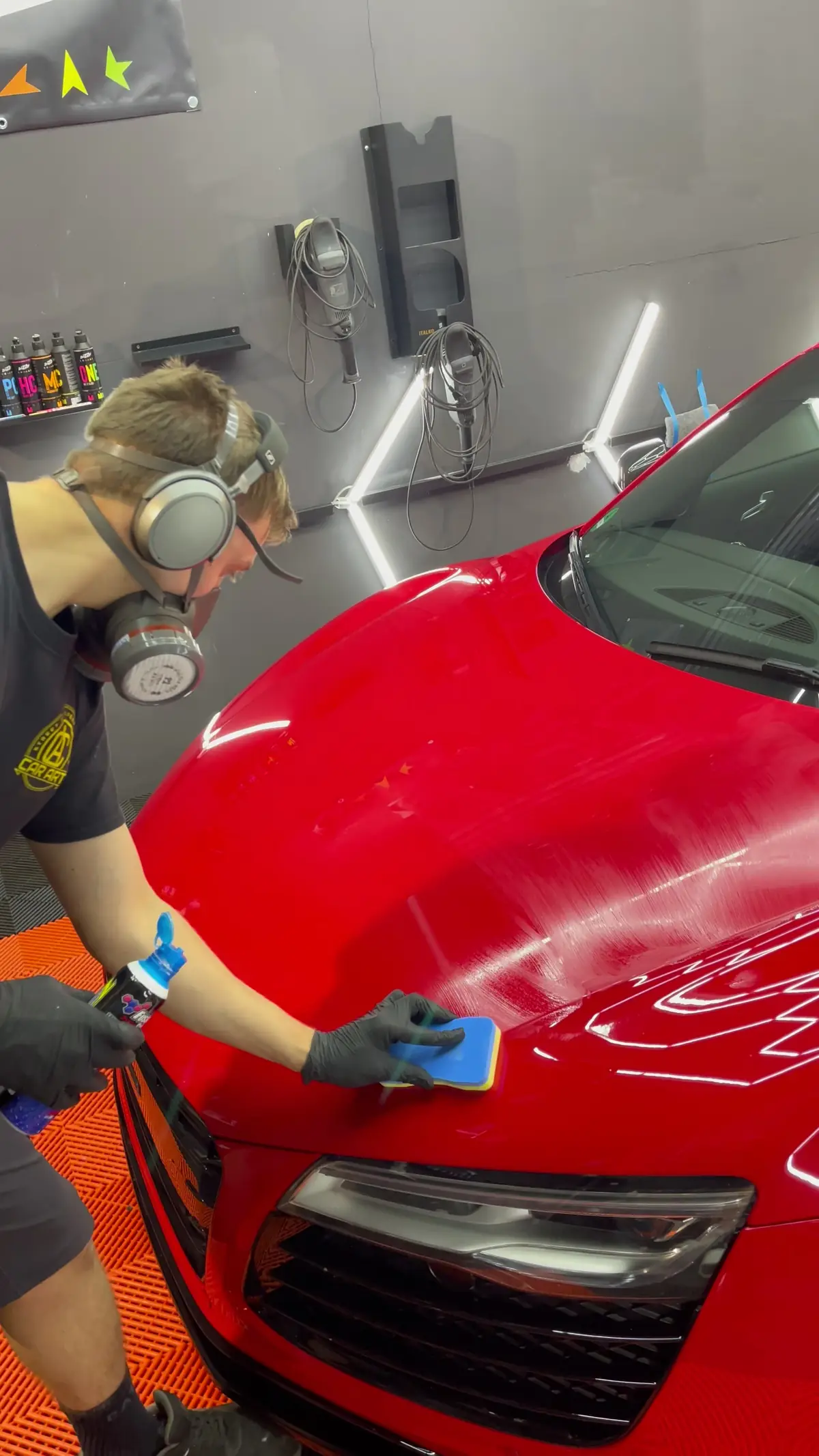 Arbeit von Hand an der Motorhaube eines roten Audi R8
