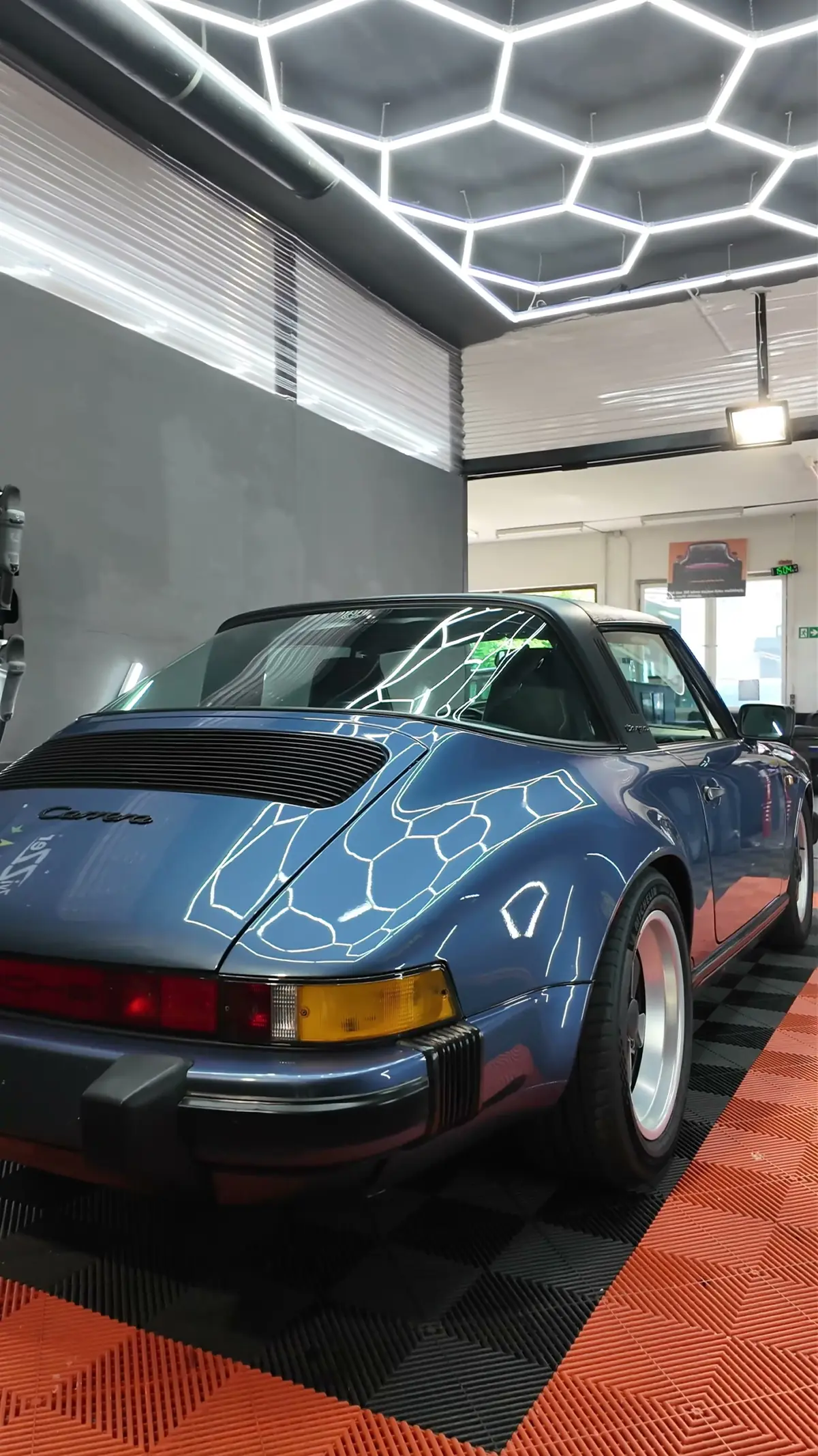 Heck eines blauen Porsche 911 Targa unter dem Hexagon-Licht