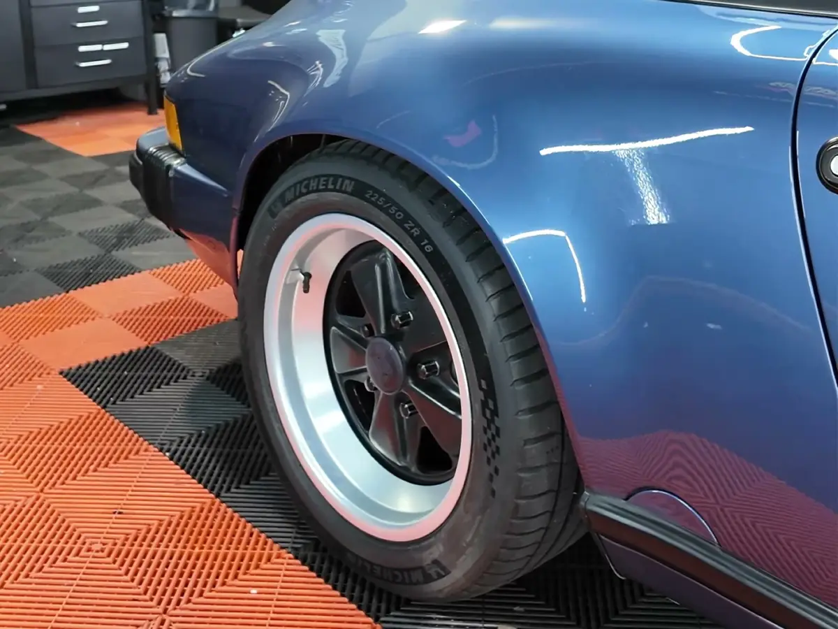 Hinterrad mit Michelin Reifen an einem blauen Porsche 911 Targa in unserer Werkstatt
