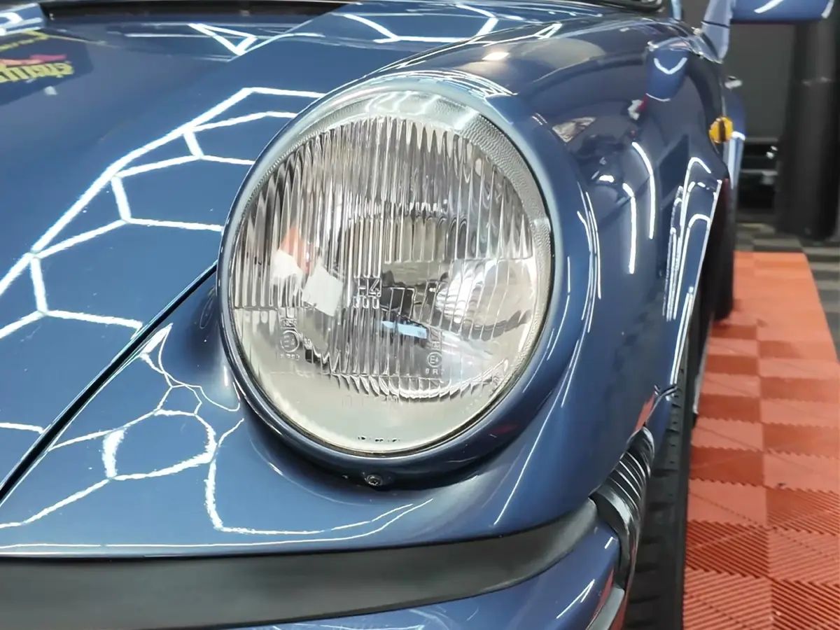 Scheinwerfer und glänzender Lack eines blauen Porsche 911 Targa nach der Keramikversiegelung