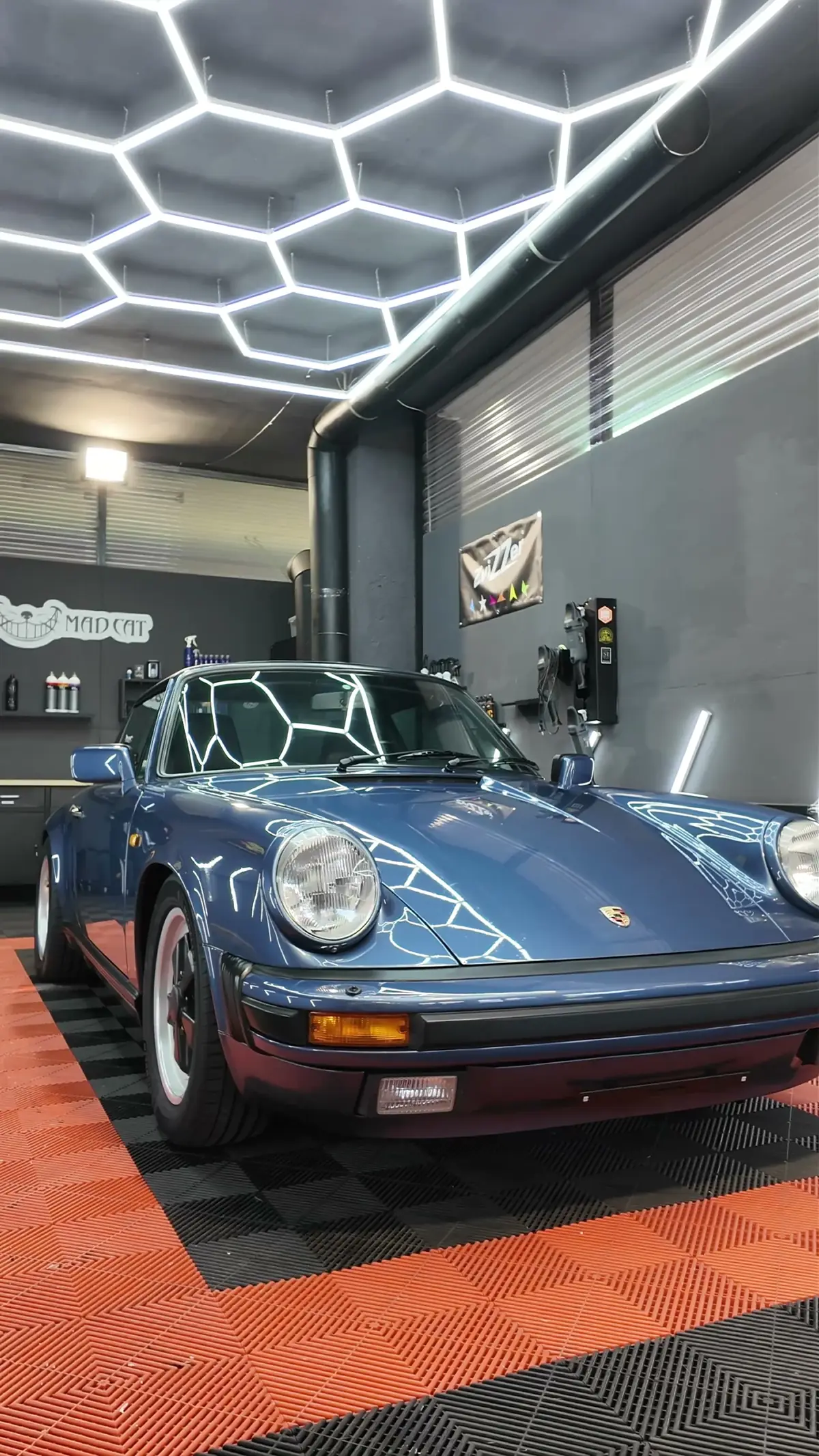 Blauer Porsche 911 Targa unter dem Hexagon-Licht in unserer Werkstatt