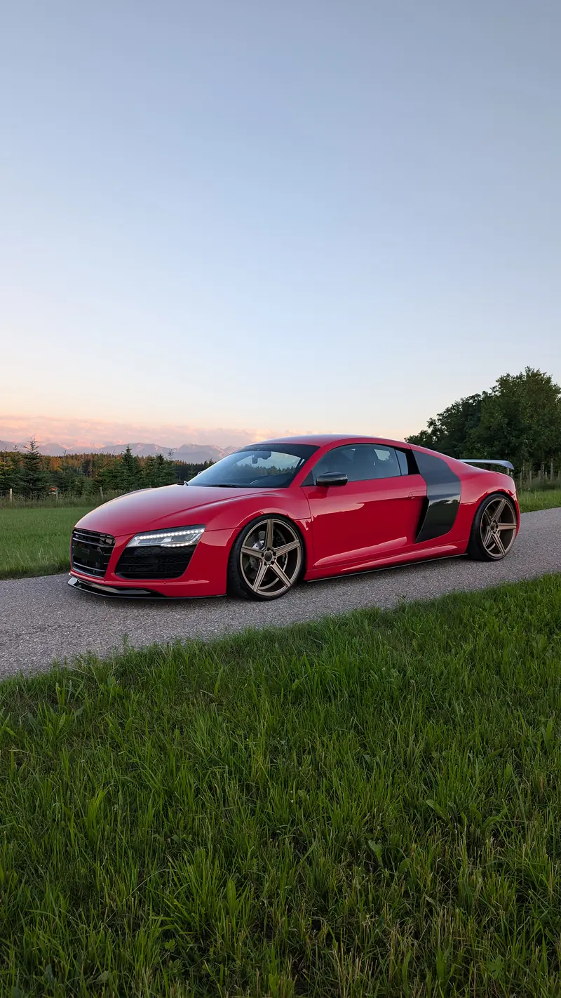 Roter Audi R8 V10 im Abendlicht vor den Alpen