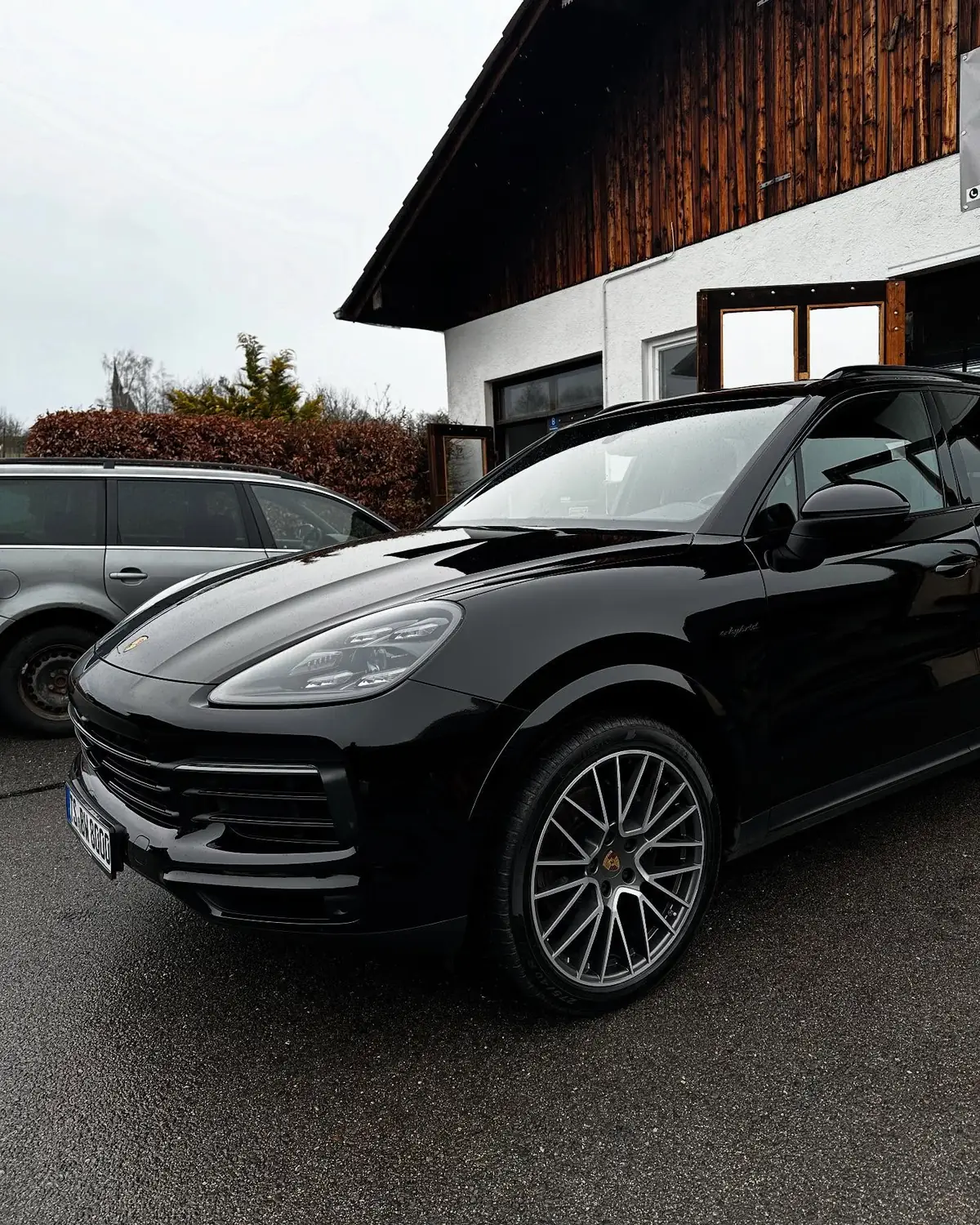 Schwarzer Porsche Cayenne vor einem Haus